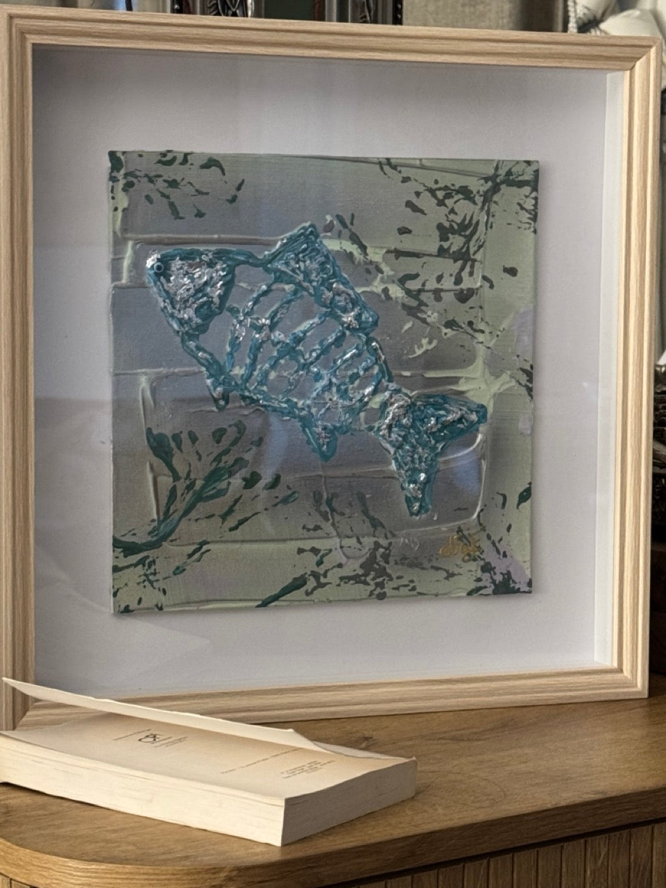 tableau encadré avec poisson en relief et texture bleue et argent
